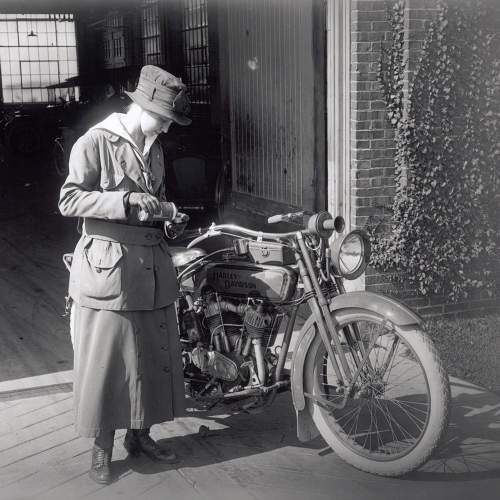 mulher perto de uma moto em 1900