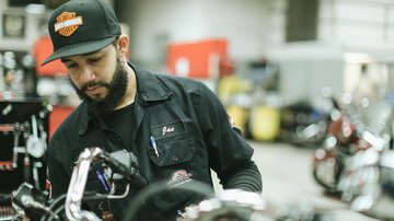 tecnico della manutenzione harley-davidson al lavoro su una moto