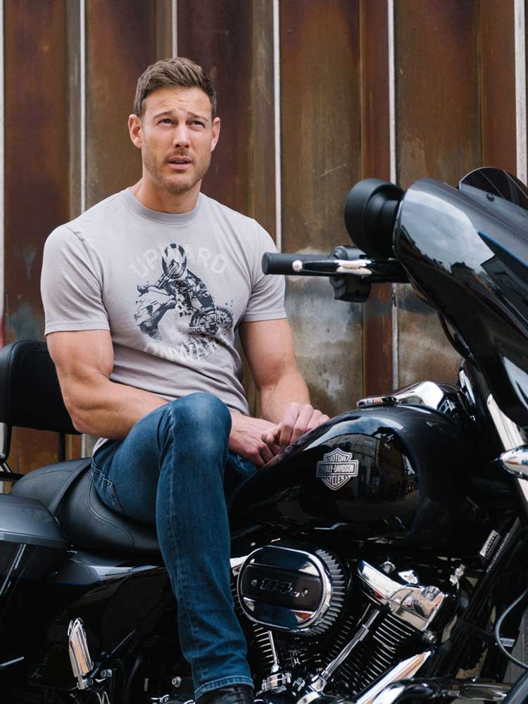 man in a t-shirt sitting on a motorcycle