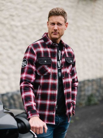 man in a shirt standing next to a motorcycle