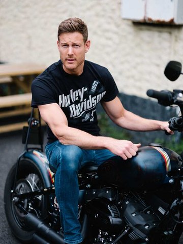 man in a t-shirt sitting on a motorcycle
