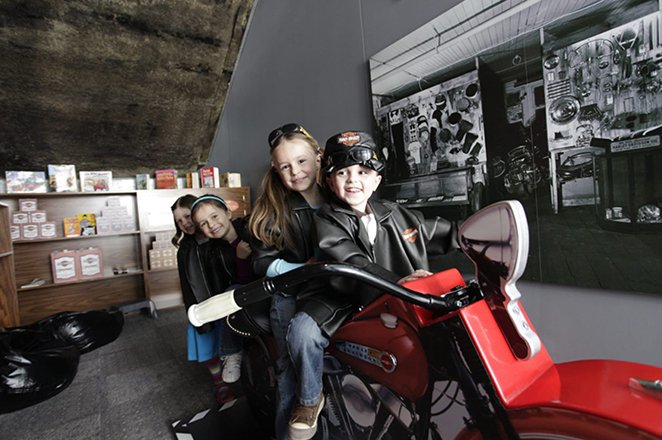 Harley-Davidson® 상상 스테이션에 앉아있는 아이들