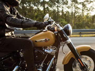 男子骑着一辆黄色摩托车