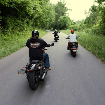 Bikers riding on back road 