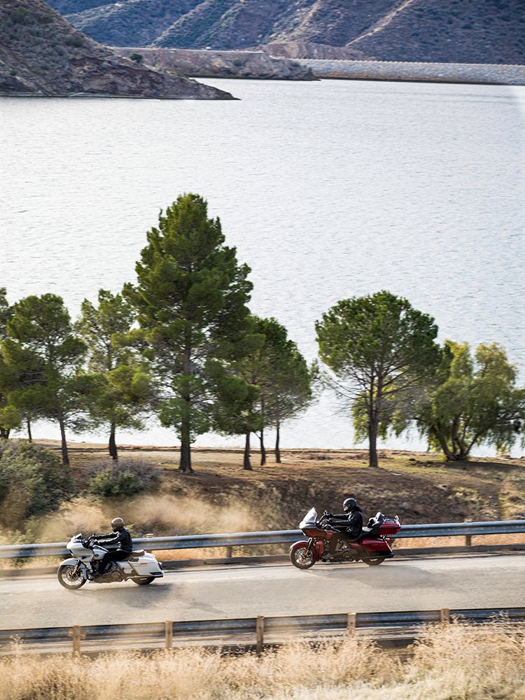 harley-davidson touring motorcycles riding along lake