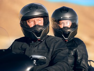 deux personnes sur une motocyclette avec un équipement h-d