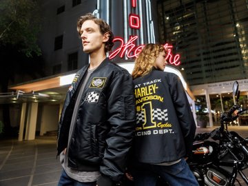 Man and woman standing next to each other wearing Harley-Davidson jackets