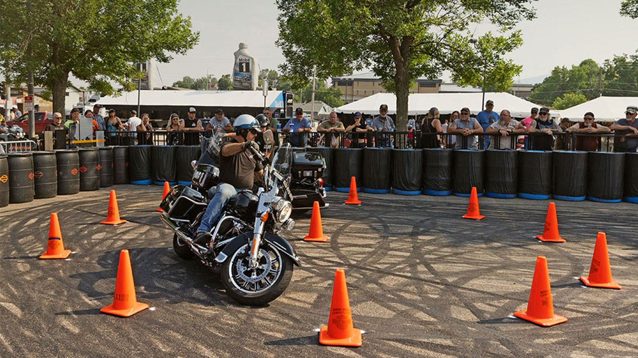 Мужчина на полицейском мотоцикле проезжает между конусами