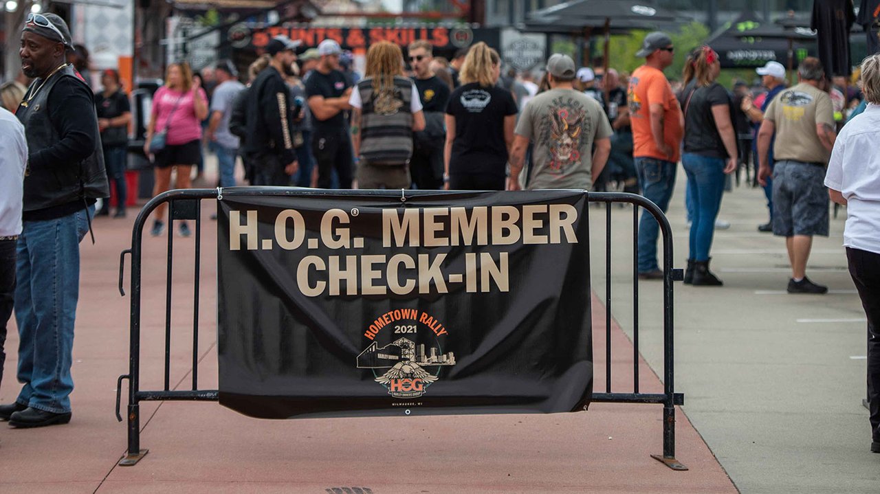 Placa do Check-in do H.O.G. com pessoas aguardando na fila