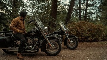 man on parked motorcycle in the woods