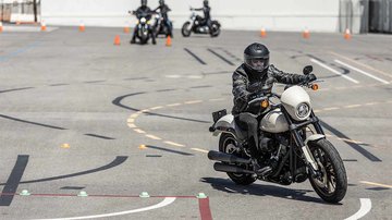 People learning to ride a motorcycle on a training range