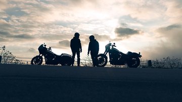 Silhouette of two motorcycles parked and two riders