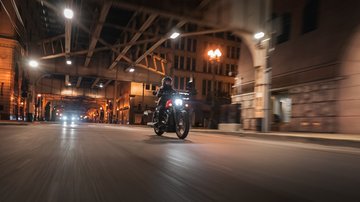 Nightster Special biker rides through city streets at night