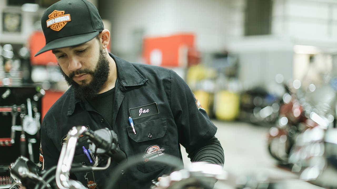 harley-davidson service technician working on motorcycle