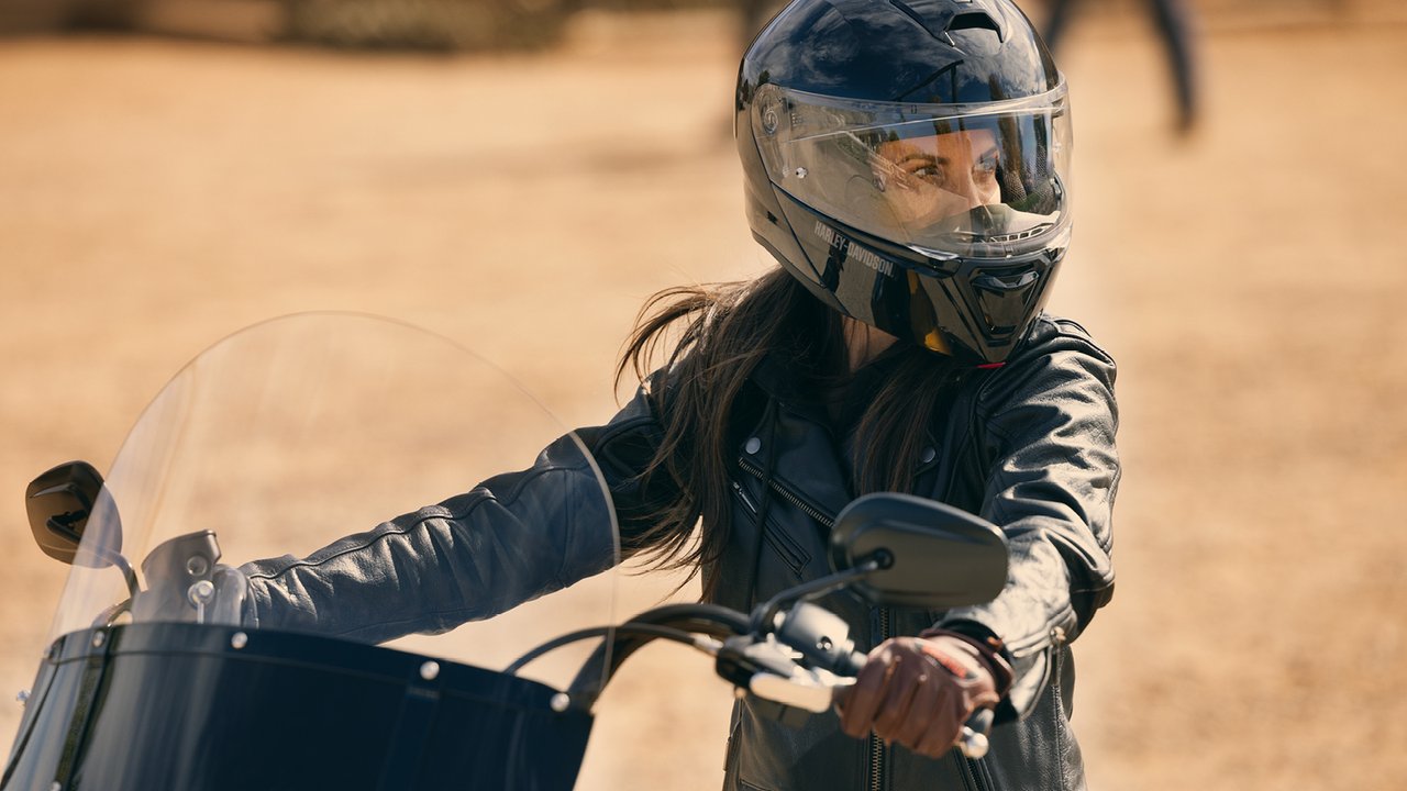 Femme portant un casque au guidon de sa moto