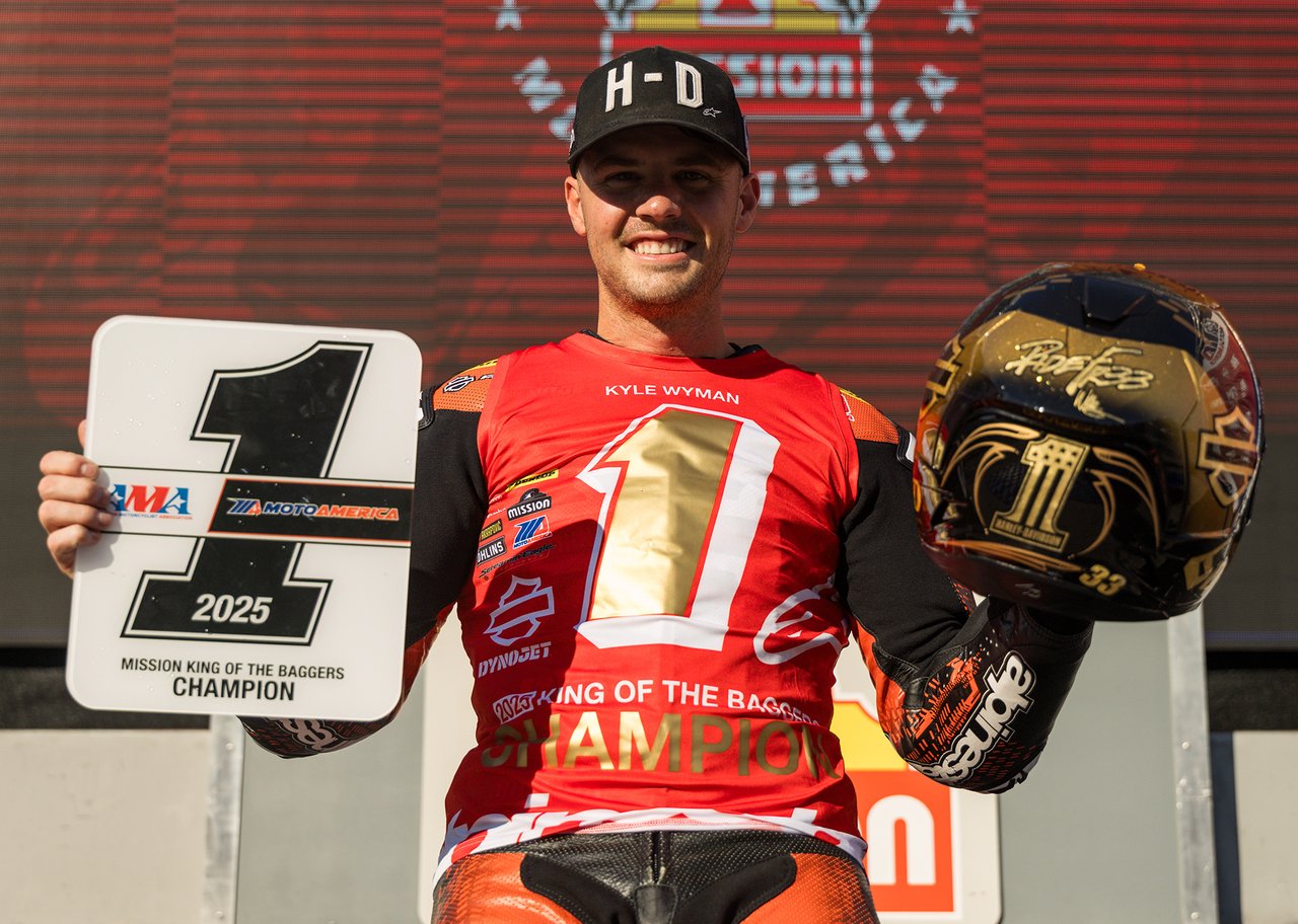 kyle wyman holding number one plate and gold helmet