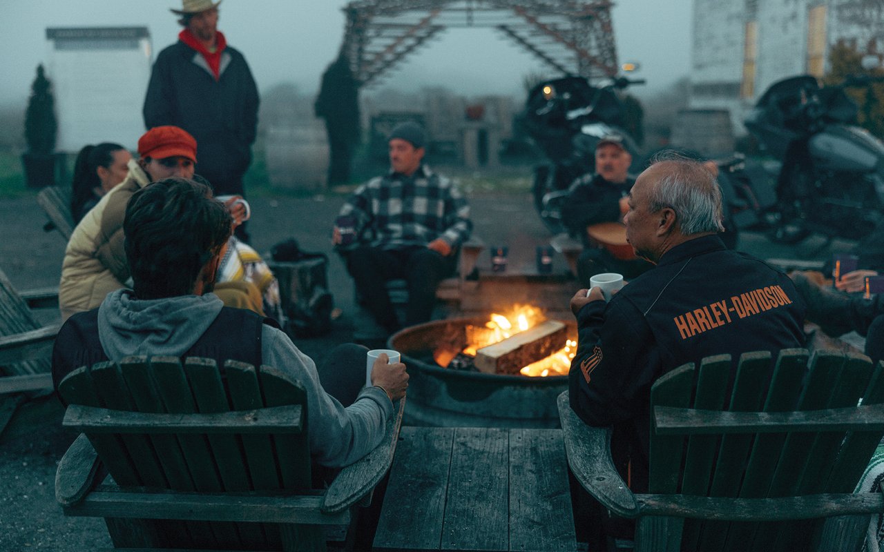 Trung and Cory Tran sit at camp fire with other bikers