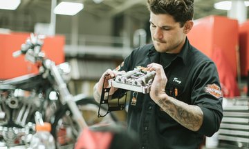 Hombre haciendo servicio de mantenimiento a una motocicleta