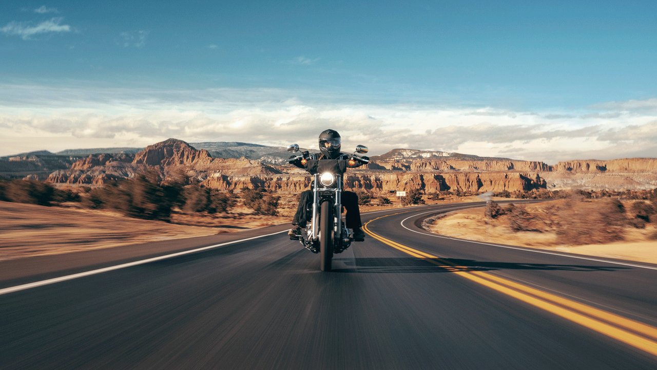 Rijdende motor op een weg door de woestijn