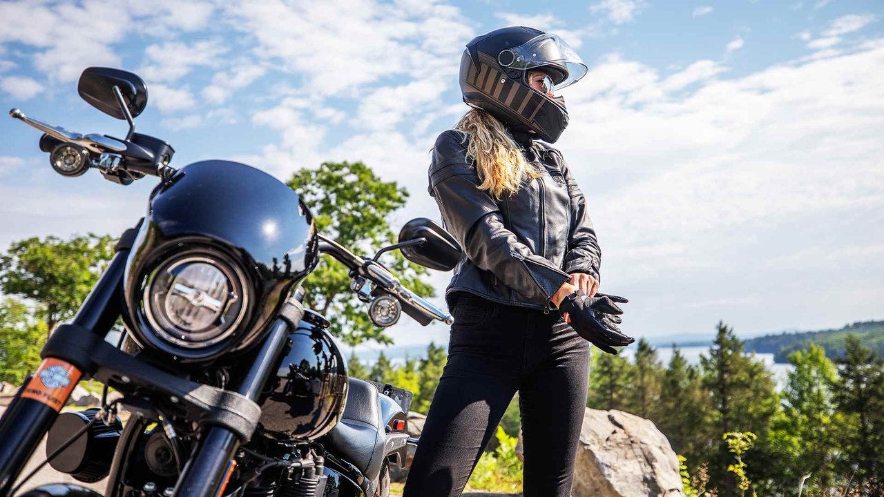 woman next to motorcycle getting ready to ride