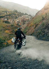 Motorcycle rider going up mountain trail