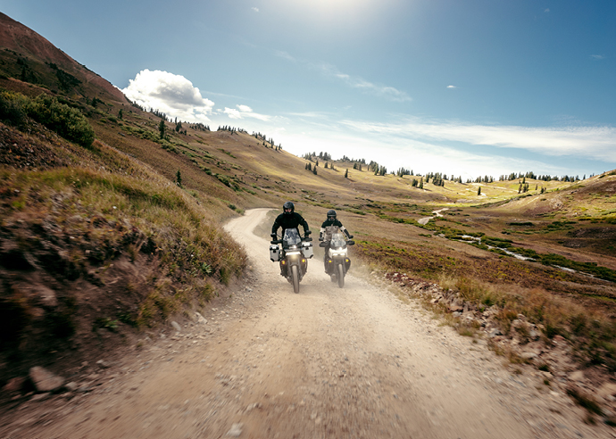 Two motorcycle riders riding on dirt trail