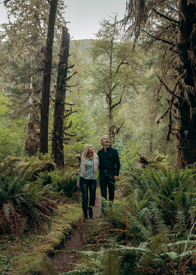 Leticia Cline and Mike Wolfe walk through woods in The Olympic Peninsula, WA. 