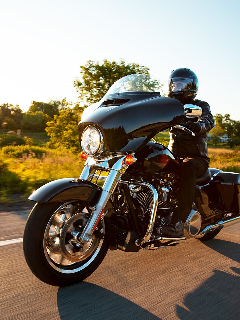 Una motociclista en una curva en una Electra Glide Standard 2022 de Harley-Davidson en Vivid Black