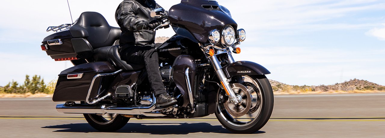 Personne sur un modèle Harley-Davidson Ultra Limited 2022 photographié sur route, avec paysage rocheux en arrière-plan