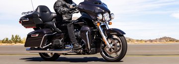 騎士以岩石為背景，騎乘 2022 Harley-Davidson Ultra Limited 重車沿著公路飛馳
