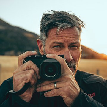 Fényképezőgépet tartó férfi