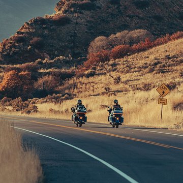 Motociclistas en Ultra Limited conduciendo en un camino rural