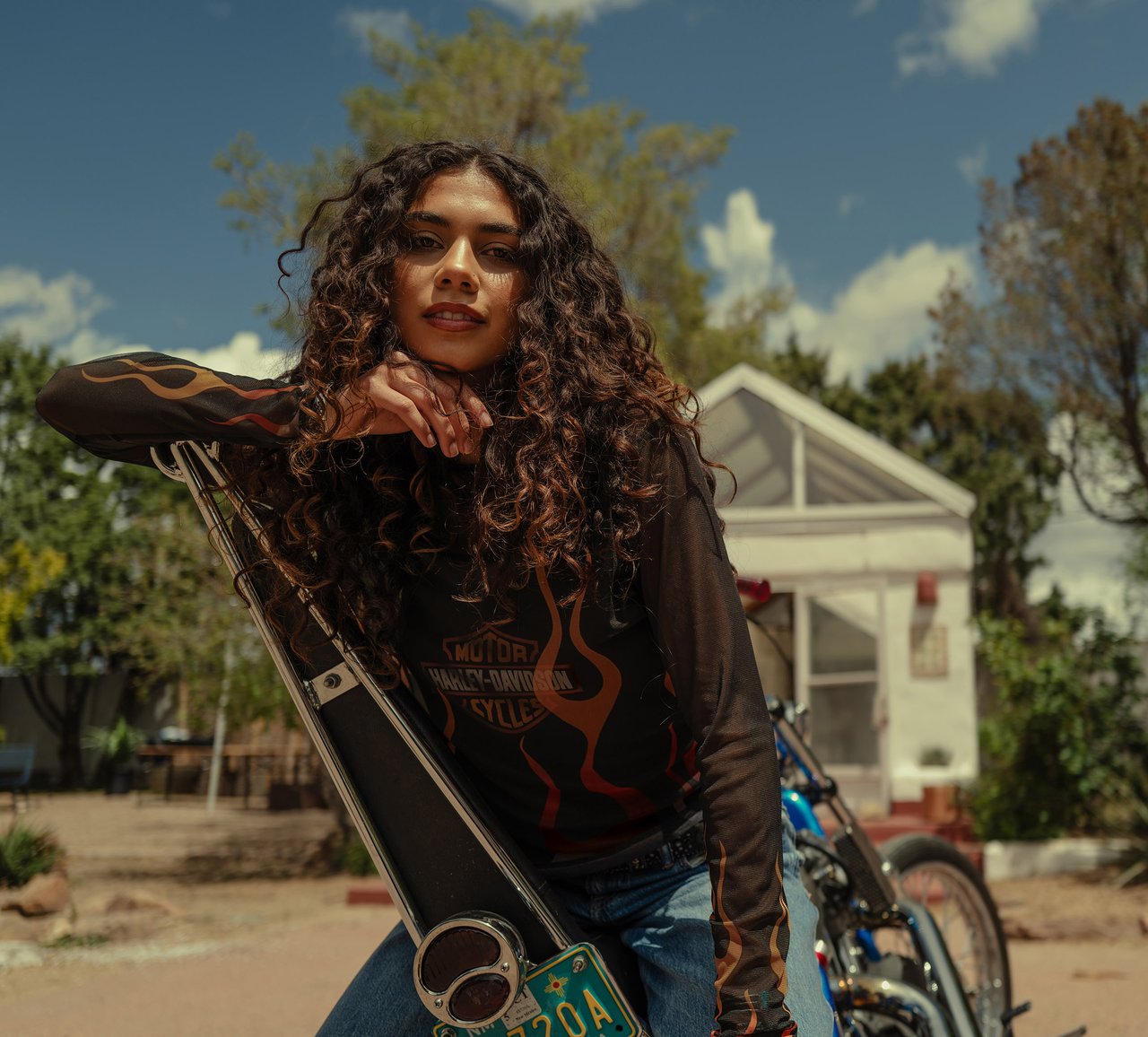 women's black & orange long sleeve shirt sitting on a motorcycle