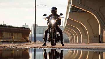 rider on motorcycle under bridge