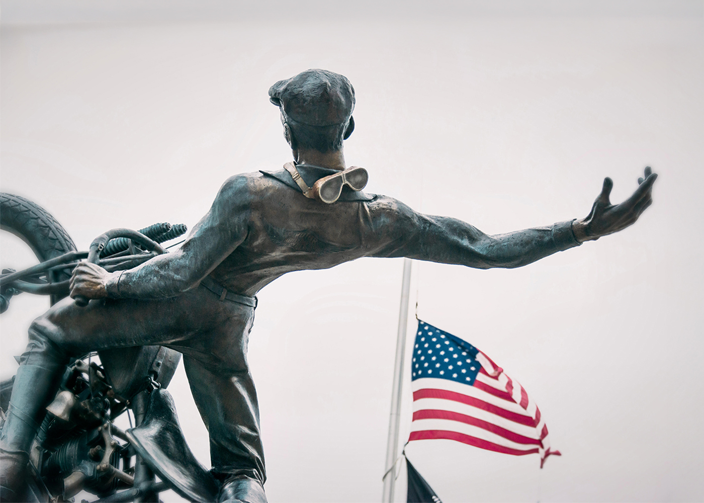 Motorcycle rider statue with American flag in background