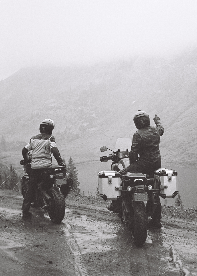 Two riders look at trails in distance