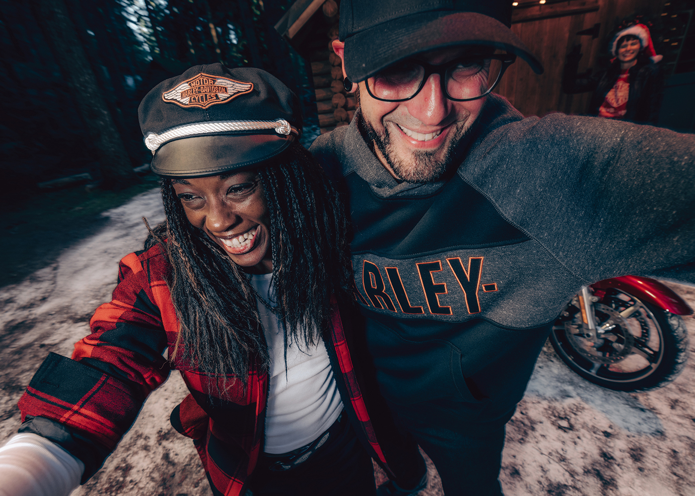 man and woman standing in front a log cabin