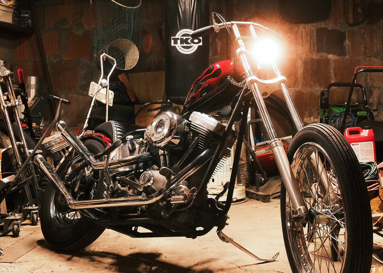The authors custom-built chopper with a red flame paint job parked in his garage.