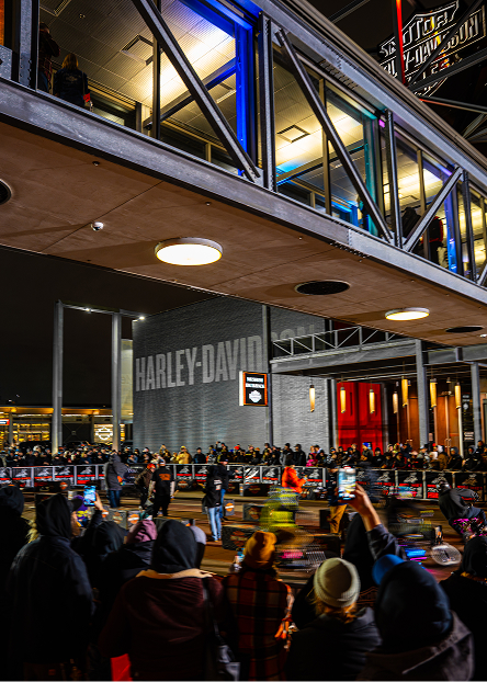Audience watches a flat track race beneath an overhead walkway at the Harley-Davidson Museum