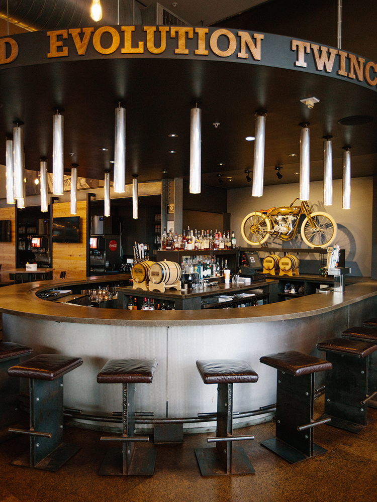 Circular bar area with mounted motorcycle above counter and signage