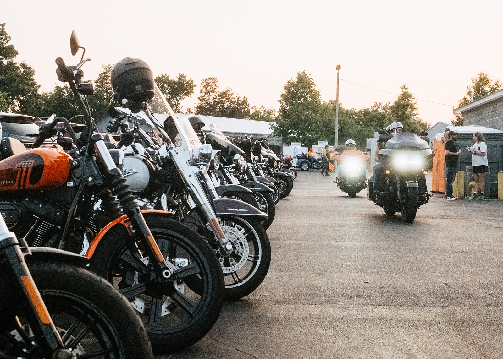 A low photo of bikes parked for an event at Smoky Mountain Harley-Davidson with two bikes riding towards the camera.