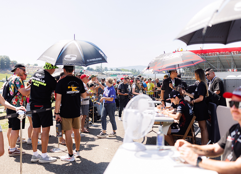 Fans line up at a Harley-Davidson race weekend autograph session as riders meet supporters trackside