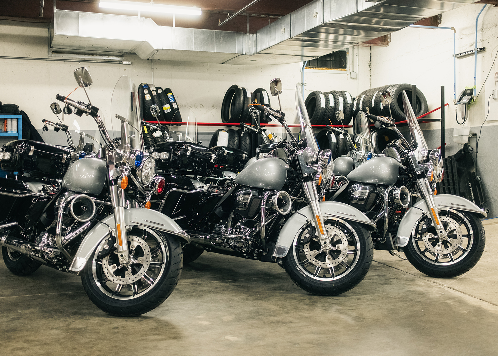 Three police motorcycles await maintenance in the service department at Harley-Davidson of Nassau County.