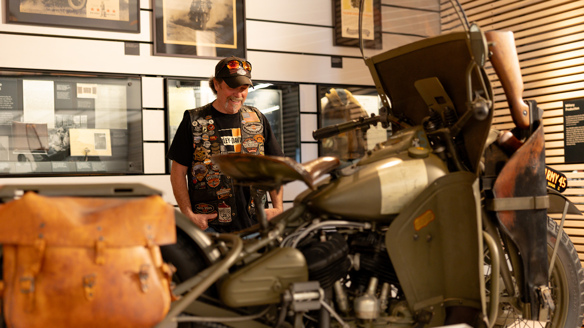 Visitor looking at vintage motorcycle inside museum exhibit