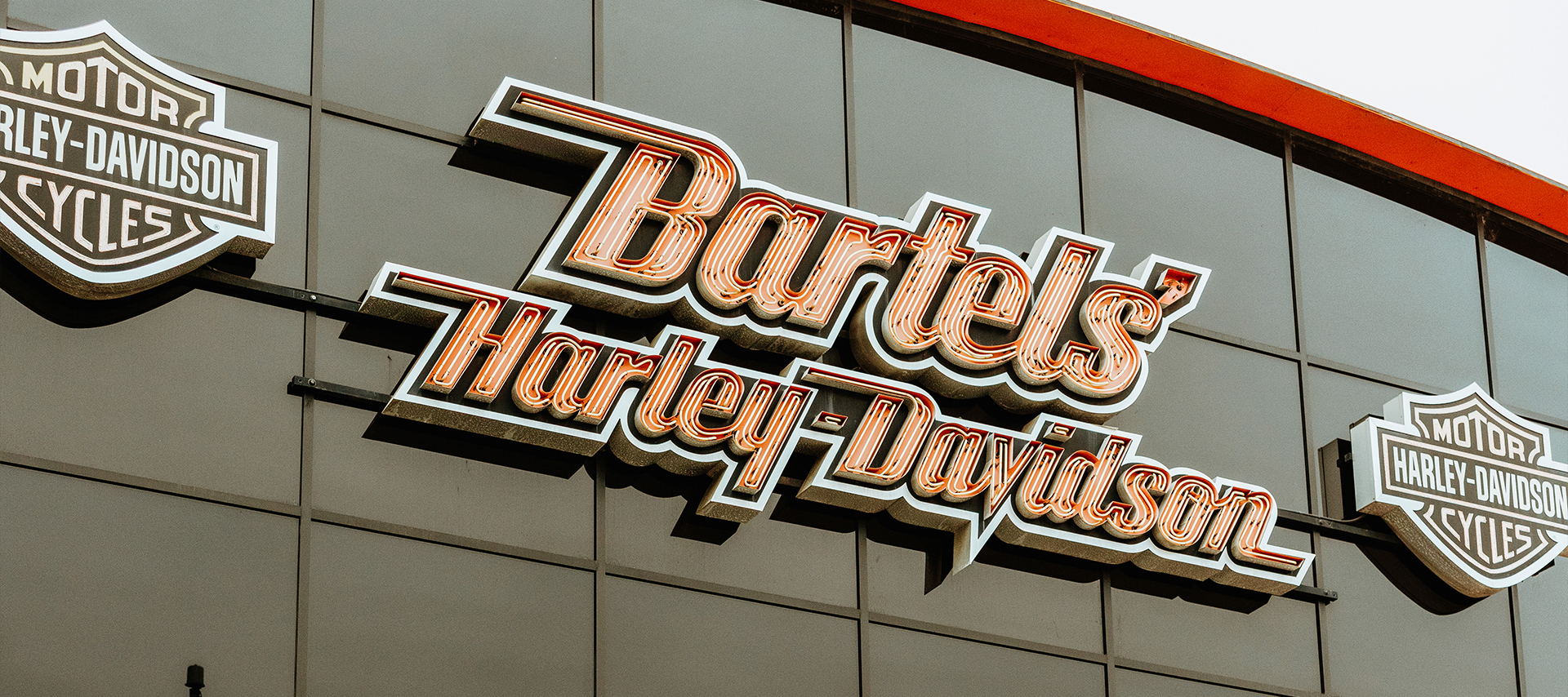 Bartel’s Harley-Davidson storefront with bikers and motorcycles out front.