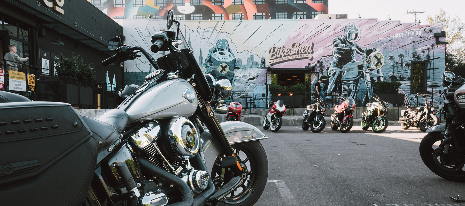 A Harley-Davidson Heritage Classic motorcycle parked at the Bike Shed surrounded by other motorcycles