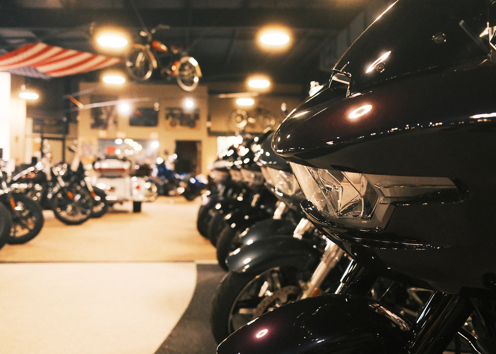 A close up of the front of a Harley-Davidson Road Glide with a row of motorcycles extending into the background.