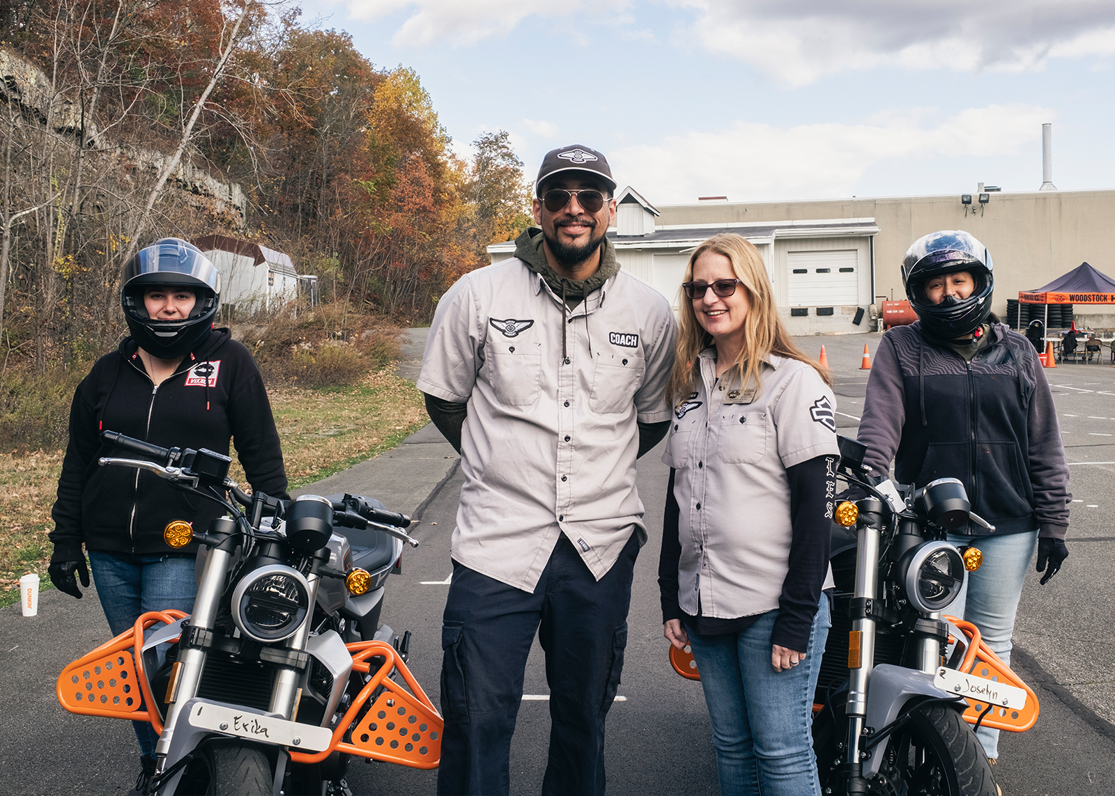 Two H-D® Riding Academy students along with instructors pose with motorcycles in the parking lot at Woodstock Harley-Davidson.