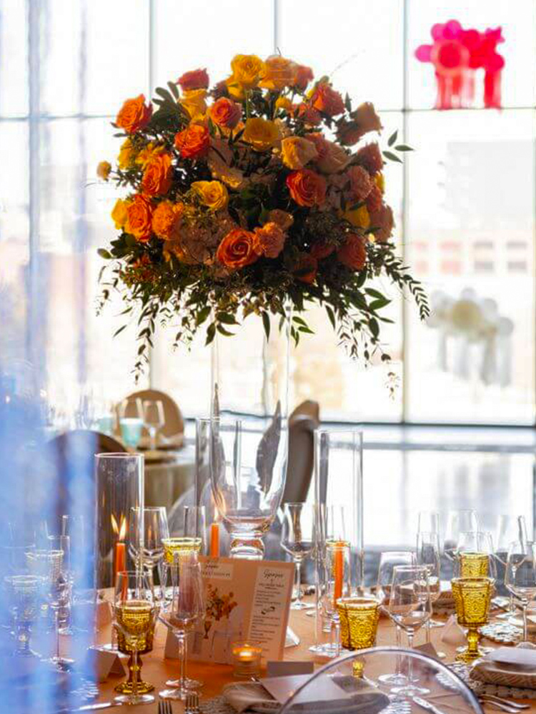 Elegant dining table with floral centerpiece and glassware near large windows