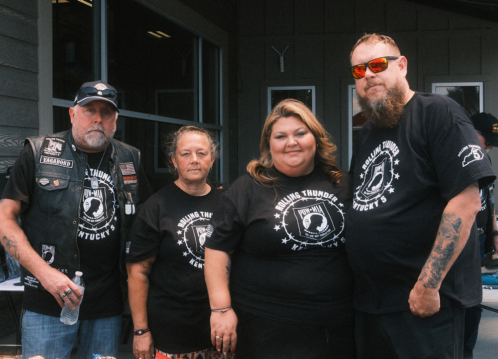 Members of Rolling Thunder riding group gather outside the dealership wearing matching event T-shirts